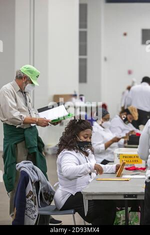 Detroit, Michigan, Stati Uniti. 2 Nov 2020. Il giorno prima delle elezioni presidenziali del 2020, i lavoratori del Dipartimento delle elezioni di Detroit pre-elaborano i voti degli assenti per prepararli a contare sul giorno delle elezioni. L'uomo nel cappello verde è uno sfidante delle elezioni. Credit: Jim West/Alamy Live News Foto Stock