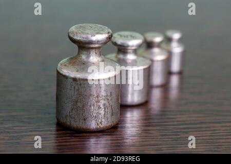 Un set di pesi di ferro graffiati vecchi per una bilancia di farmacia. Foto Stock