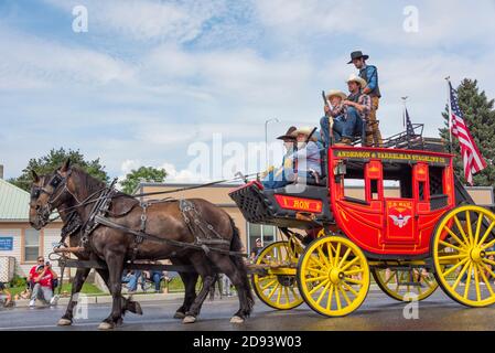 Carrozza del giorno vecchio che tiene la bandiera americana al Grand Parade durante Omak Stampede, Stato di Washington, Stati Uniti Foto Stock