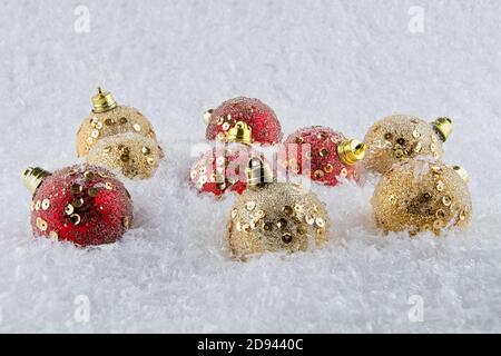Red e Gold Natale baubles su una certa neve Foto Stock