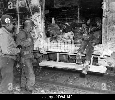 Due soldati statunitensi che guardano i prigionieri morti sul treno ferroviario nel campo di concentramento non identificato in Germania, aprile 1945 Foto Stock