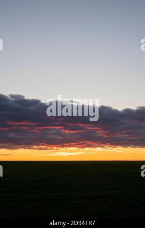 Banda di nuvole di pioggia al tramonto sulla campagna del cotswold. Cotswolds, Gloucestershire, Inghilterra Foto Stock