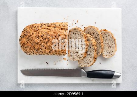 Pane multigrein affettato su consistenza di marmo. Vista dall'alto del pane sano con semi Foto Stock