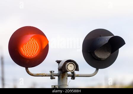 Semaforo rosso all'incrocio ferroviario. Primo piano. Foto Stock