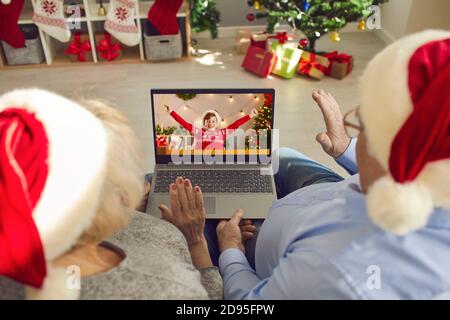 Nonni in Santa caps video che chiama il loro nipote felice Il giorno di Natale Foto Stock