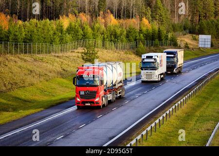 Tre camion che trasportano il carico lungo l'autostrada in un giorno dell'autunno, vista rialzata. Salo, Finlandia. 29 ottobre 2020. Foto Stock