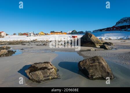 La famosa spiaggia di sabbia dall'aspetto tropicale vicino a Ramberg sulla Lofoten isole in Norvegia in chiaro giorno d'inverno con neve-rivestito montagne e cielo blu Foto Stock