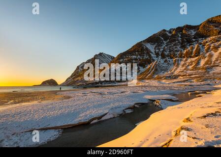 La famosa spiaggia di sabbia nei pressi di Haukland durante il tramonto sul Lofoten isole in Norvegia in chiaro giorno d'inverno con neve-rivestito montagne e cielo blu Foto Stock