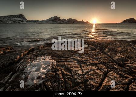 La famosa spiaggia di sabbia nei pressi di Haukland durante il tramonto sul Lofoten isole in Norvegia in chiaro giorno d'inverno con neve-rivestito montagne e cielo blu Foto Stock