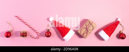 Layout creativo Chistmas fatto di cappello Babbo Natale e decorazione su rosa. Minimo inverno appartamento disposizione Natale concetto. Natale Capodanno appartamento Lay. Lungo Foto Stock