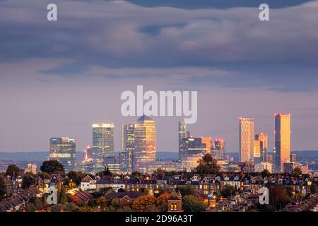 Regno Unito, Inghilterra, Londra, vista dello skyline da Muswell Hill del centro di Londra con alloggi suburbani a Crouch End e il CBD di Canary Wharf a Docklands, crepuscolo Foto Stock