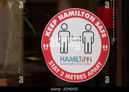 Mantenere Hamilton sicuro rimanere a 2 metri di distanza segno fuori negozio a Hamilton, Lanarkshire meridionale, Scozia, Regno Unito durante le misure locali coronavirus Foto Stock