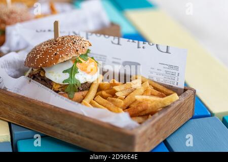 Primo piano di hamburger di manzo su sfondo tavola di legno. Hamburger di carne alla griglia hamburger, lattuga, pomodoro e uova fritte. Hamburger gourmet fatto a mano Foto Stock