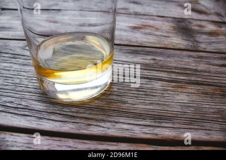 Primo piano di un bicchiere di whisky su un legno tabella Foto Stock