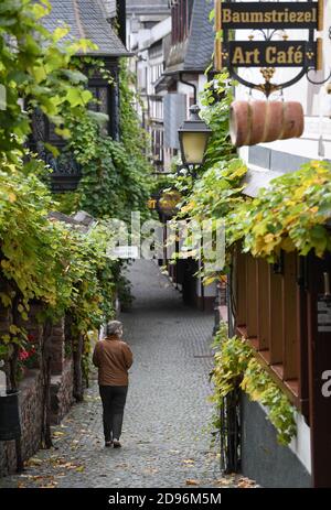 03 novembre 2020, Hessen, Rüdesheim: Una donna passeggiava da sola attraverso la famosa Rüdesheimer Drosselgasse. Un blocco parziale di quattro settimane è in vigore in tutta la Germania per rallentare la diffusione del coronavirus. Foto: Arne Dedert/dpa Foto Stock