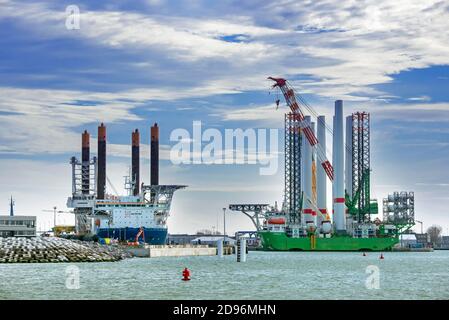 Navi di installazione Apollo e Vole Au Vent ormeggiate presso il terminal di carico pesante REBO nel porto di Ostend, Belgio, che caricano turbine eoliche per l'azienda eolica SeaMade Foto Stock