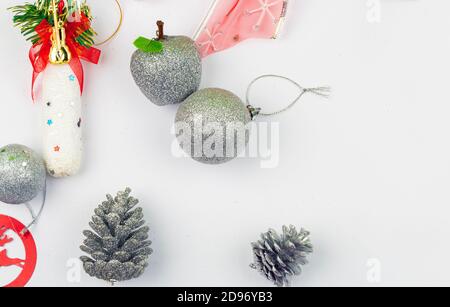 Decorazioni per alberi di Natale su un tavolo pronto per appendere, coni di pino, mela, palla d'argento e archi Foto Stock