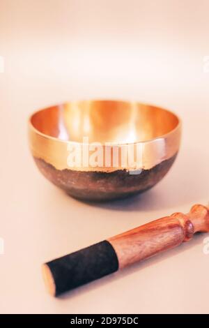 Ciotola di canto tibetano in bronzo con bastone di legno sul bianco sfondo Foto Stock