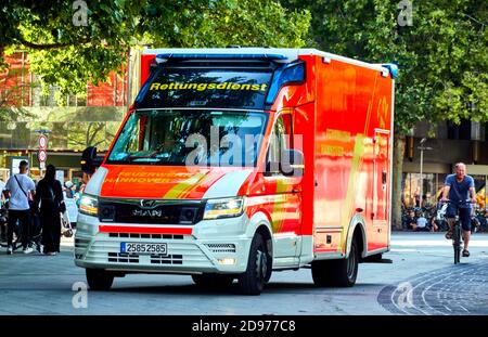L'ambulanza rossa del servizio di soccorso attraversa il pedone zona nel centro della città Foto Stock