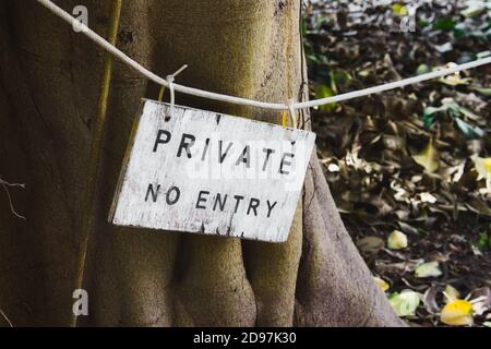 Un segno di legno dipinto di bianco con le parole Private No Voce scritta Foto Stock