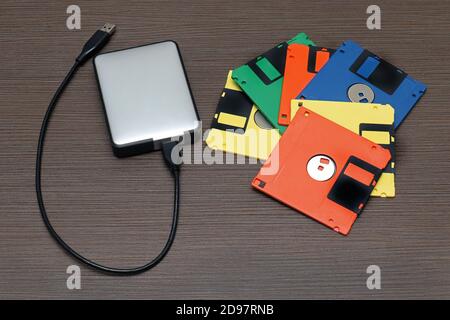 Floppy disk retrò colorati e moderno disco rigido on tavolo di legno Foto Stock