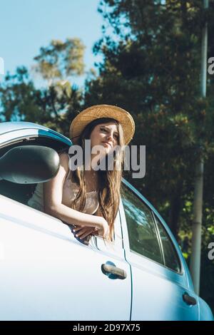 Ragazza teen che ondeggiava felicemente attraverso la finestra dell'auto Foto Stock