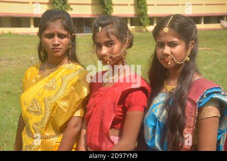 Tre ragazze bengalesi adolescenti che indossano saree e gioielli come anelli di naso orecchini collana maang tika con lunghi capelli neri, messa a fuoco selettiva Foto Stock