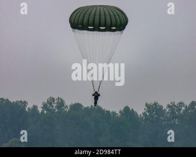 SAINTE MERE L'EGLISE, FRANCIA - 6 GIUGNO 2019. Silhouette della squadra dell'esercito skydiver contro il cielo drammatico. Per la libertà francese della normandia dopo il secondo mosto Foto Stock