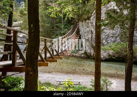 Tipico ponte sospeso in legno che attraversa il fiume Savinja in Slovenia Foto Stock