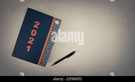 Notepad obiettivi per il nuovo anno 2021. Foto ad alto angolo di un notebook a spirale e di una penna sulla scrivania dell'ufficio con spazio per la copia. L'elenco dei piani e delle finalità f Foto Stock
