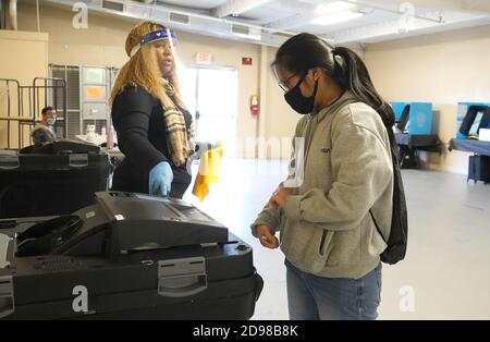 Lawrenceville, Stati Uniti. 03 Nov 2020. Il lavoratore di sondaggio Sandy Spence aiuta la prima volta che l'elettore Tracy Dang entrare il suo voto in una macchina il giorno delle elezioni alla fiera della contea di Gwinnett a Lawrenceville, Georgia martedì 3 novembre 2020. Foto di Tami Chappell/UPI Credit: UPI/Alamy Live News Foto Stock