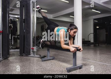 Giovane donna caucasica che fa un esercizio in palestra Foto Stock