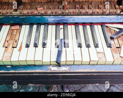 Un frammento di un vecchio pianoforte rotto con tasti rotti e senza copertura. Foto di primo piano Foto Stock