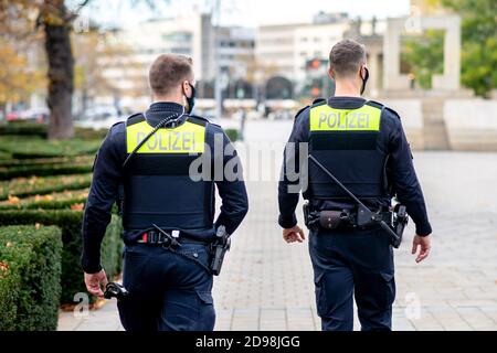 Hannover, Germania. 03 Nov 2020. Gli agenti di polizia controllano la piazza dell'opera per assicurarsi che vengano osservate le restrizioni di contatto. A seguito di un aumento delle infezioni da corona nella regione di Hannover, le maschere sono ora obbligatorie per le aree molto frequentate negli spazi pubblici. Credit: Hauke-Christian Dittrich/dpa/Alamy Live News Foto Stock