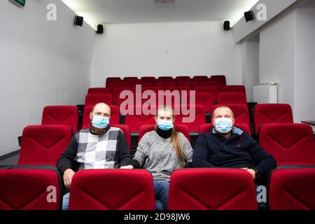 Persone al cinema con maschera di protezione che tiene la distanza per evitare il contatto fisico.Coronavirus COVID-19 protezione della malattia.Social distancing Foto Stock