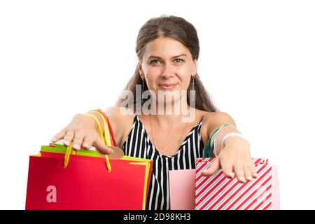 Shopaholic modello di donna adulta che mostra borse piene di borse colorate indossa un abbigliamento estivo moderno ed informale come concetto di shopping da primo piano isolato Foto Stock