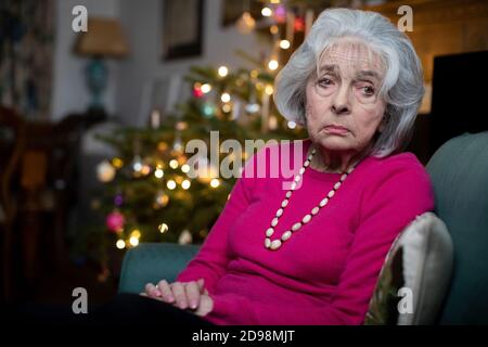 Triste e Lonely Senior Woman infelice di spendere Natale a. Solo a casa Foto Stock