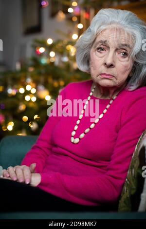 Triste e Lonely Senior Woman infelice di spendere Natale a. Solo a casa Foto Stock