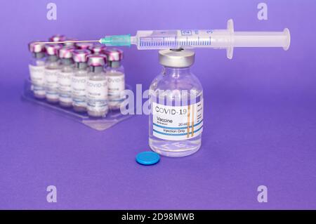 COVID-19 vaccini coronavirus su sfondo viola. Preparati per la salute, nuova normalità mondiale della salute Foto Stock