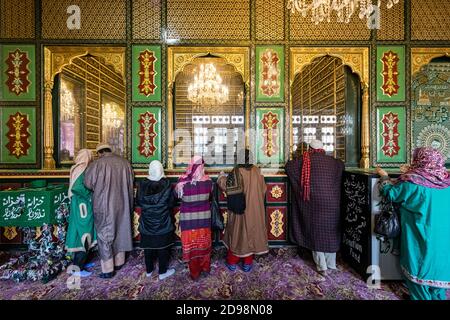 Una vista dell'intricato dipinto e decorazione all'interno del famoso Dastgeer sahib, un santuario a Srinagar, i devoti che offrono namaz. Foto Stock