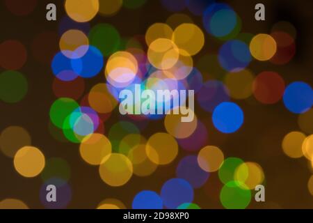 Sfondo offuscato astratto con palline colorate arancioni, verdi blu e rosse su sfondo scuro Foto Stock