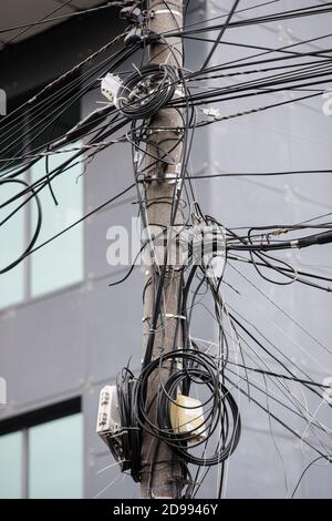 Molti cavi internet e TV non organizzati su un palo di cemento a Bucarest. Foto Stock