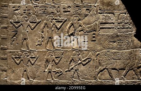 Frammento di parete dalla tomba di Neferkhau e Satbahetep (le scene sono legate al pasto funerario.) Il defunto Neferkhau e una donna chiamata Satbahetep, il registro superiore è riservato ai sacerdoti. Gli altri tre registri mostrano che i portatori di portare in merce per la ka del deceduto Satbahetep, durante il banchetto funerario. 1° PERIODO INTERMEDIO 2181–2055 a.C. Egitto, egiziano. Foto Stock