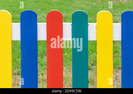 Recinzione colorata in legno, confine con il parco giochi. Primo piano Foto Stock