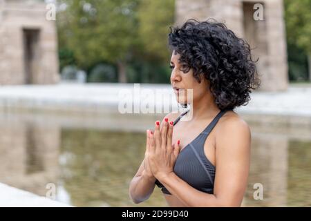 Primo piano di una donna spagnola pratica yoga all'aperto Foto Stock