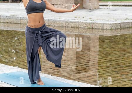 Primo piano di una donna spagnola pratica yoga all'aperto Foto Stock
