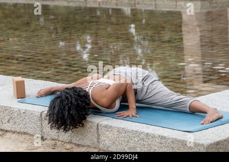 Primo piano di una donna spagnola pratica yoga all'aperto Foto Stock