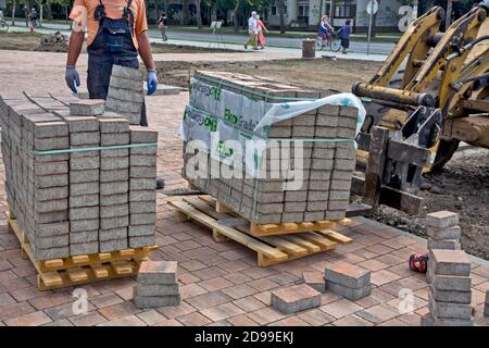 Zrenjanin, Serbia, 14 agosto 2020. Lavori per l'installazione di un marciapiede decorativo in città. Consegna di materiali su pallet con veicolo a motore. Foto Stock