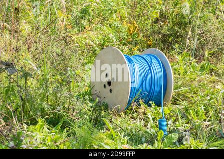 Tamburo per cavi con cavo di rete su campo verde Foto Stock