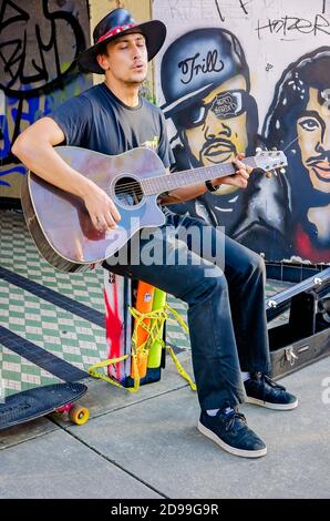 Un busker si esibisce su Dauphin Street circondato da graffiti Black Lives Matter, 31 ottobre 2020, a Mobile, Alabama. Foto Stock